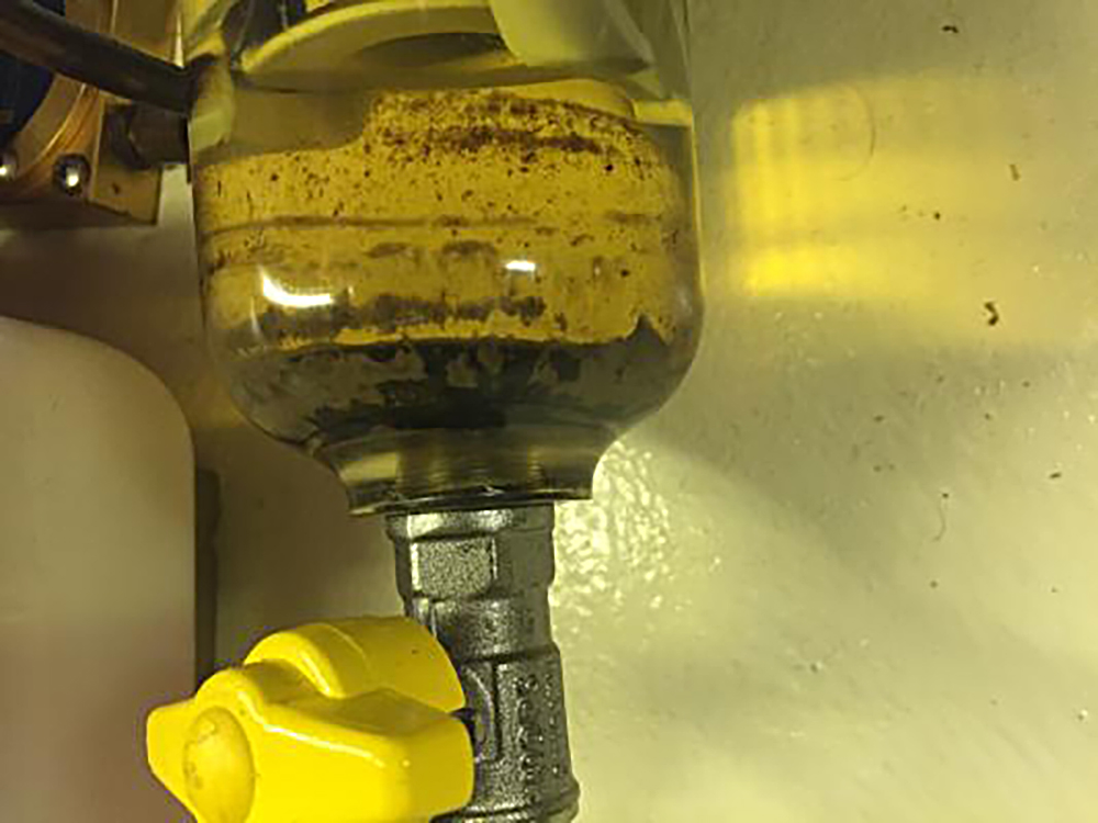 Dunkle Schwebeteile im Schauglas des Vorfilters zeigen, dass es passiert ist